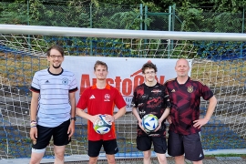 Johan Grasshoff, Trainer des deutschen Straßenfußballteams (links), und Jiri Pacourek, Leiter des Bereichs Schrittmacher im Don Bosco Jugendwerk Nürnberg (rechts), mit den beiden Fußballern aus Nürnberg, Lars H. und Justin K.