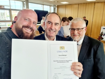 Hubert Aiwanger (Mitte) und geschäftsführender Direktor Andreas Halbig gratulieren David Metzger vom Caritas-Don Bosco Bildungszentrum zu seinen Prüfungsleistungen. 
