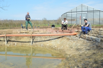 Die Teilnehmenden Robin Köcher (Mitte) und Linus Kukuk (rechts) des St. Markushof freuen sich über eine kurze Pause beim „Teichbau-Projekt“ von Ausbilder Klaus Amon (links). 