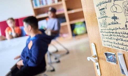 Kinder in Schülertagesstätte Oratorium im Münchner Salesianum, Tür mit bunten Bildern