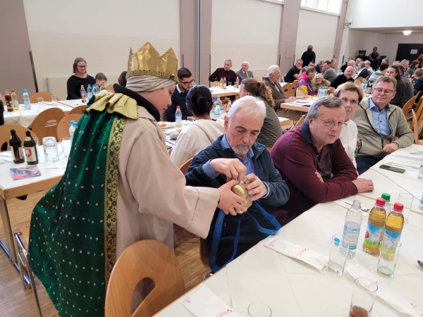 Ein Sternsinger geht durch die Reihen und sammelt für das Kindermissionswerk.